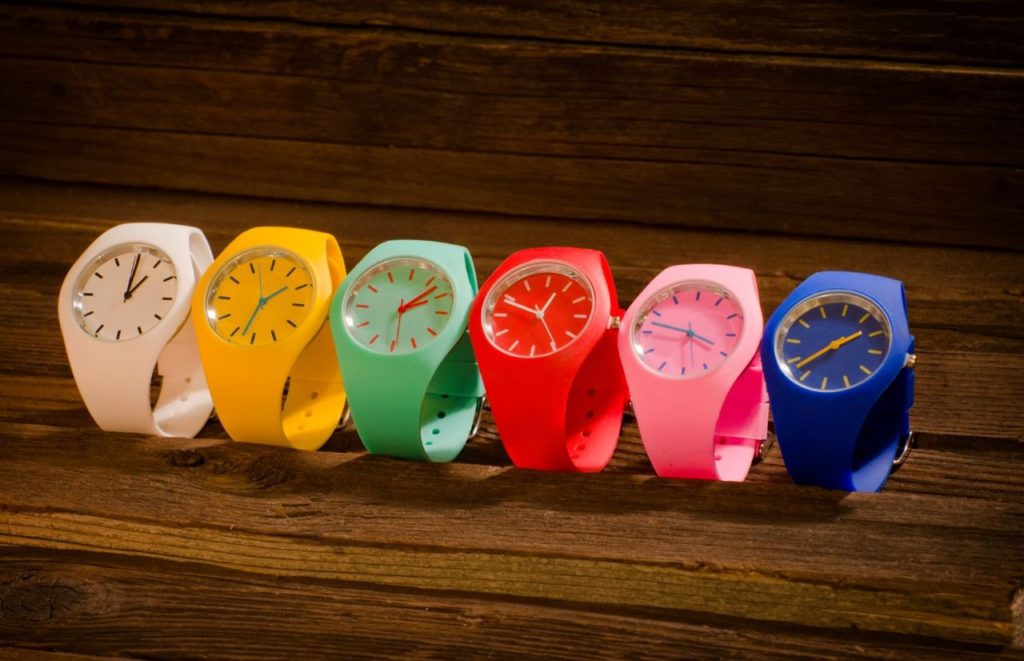Rainbow color watches on wood panel. Keep reading to get the best watch travel cases and boxes.
