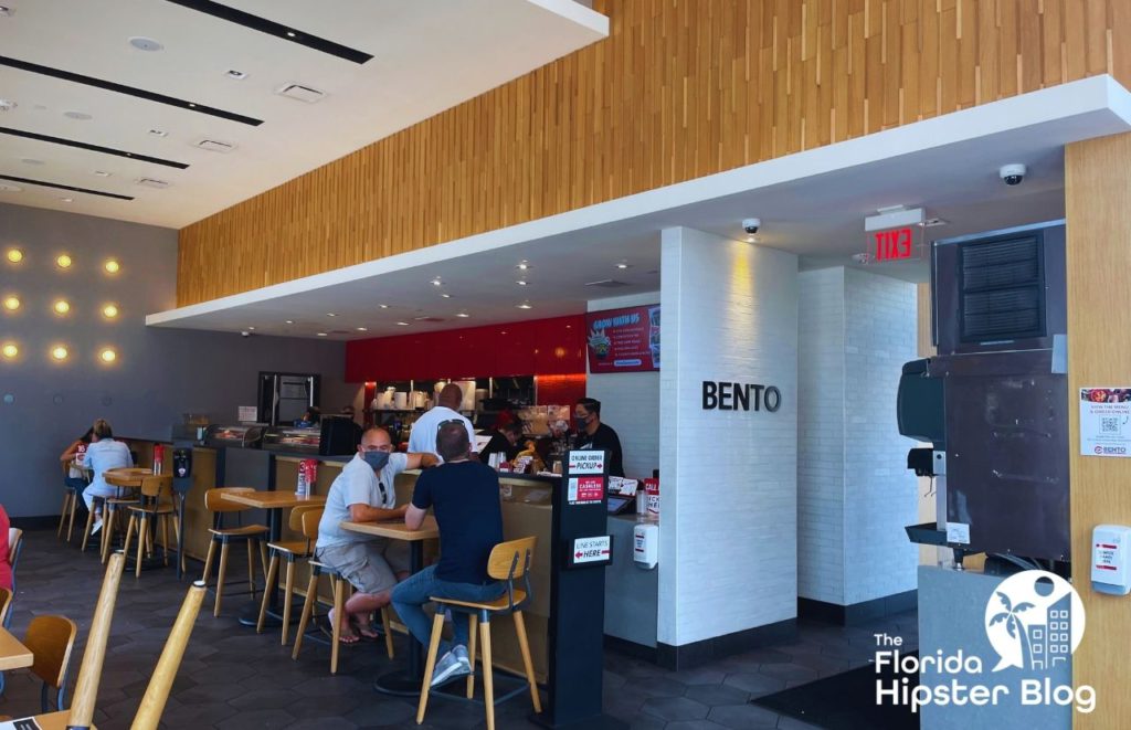 Inside Bento Restaurant in Gainesville, Florida. Two men sit at a high-top table near the counter. Keep reading to see what are the best places to get lunch in Orlando.