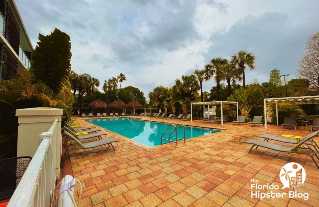 Things to do in Tampa Bay, Florida Hotel Alba. Outdoor pool area with lush greenery, sun loungers, tiki huts and cabanas. Keep reading to find out more about one of the best hotels in Tampa, Hotel Alba Tampa, Tapestry Collection by Hilton. 