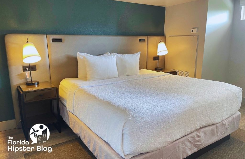 Things to do in Tampa Bay, Florida Hotel Alba. Big bed with luxurious bedding and earth tone colors in the room with ambient lighting. Keep reading to find out all you need to know about Hotel Alba Tampa. 