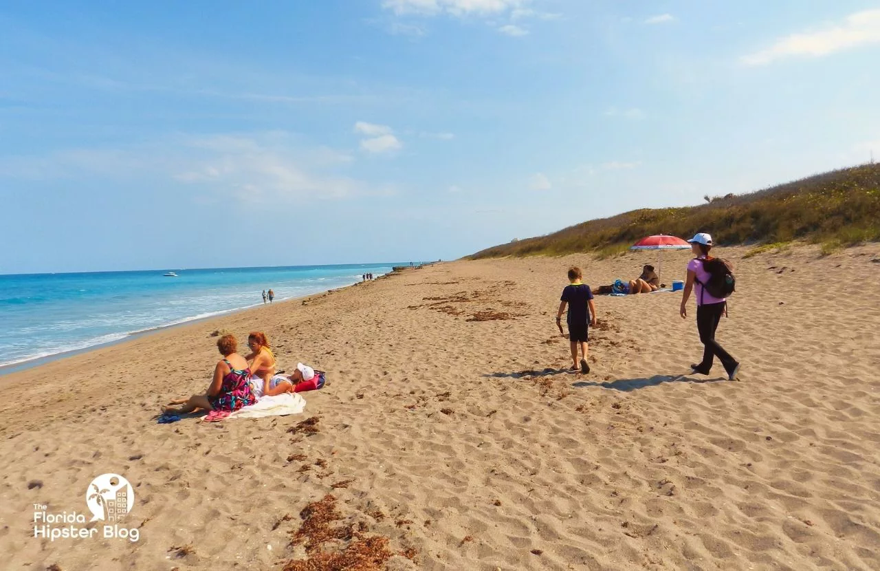 Jupiter, Florida Rocky Beach Shore with people sunbathing on the sand