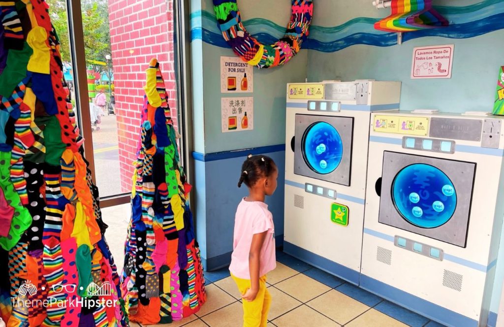 SeaWorld Orlando Resort Christmas Celebration Sesame Street Land Laundry Mat with little black girl. Keep reading for everything you need to know about Sesame Street SeaWorld. 